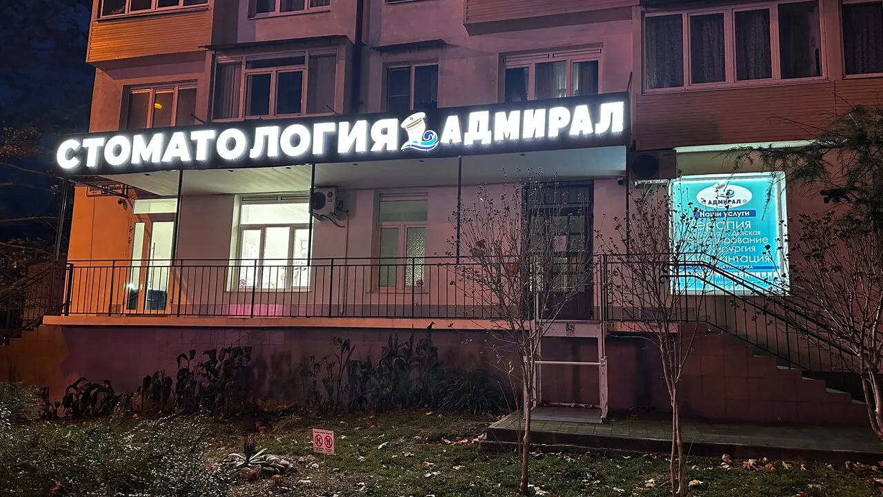Вывеска «Стоматология Адмирал» вечером на Донской улице